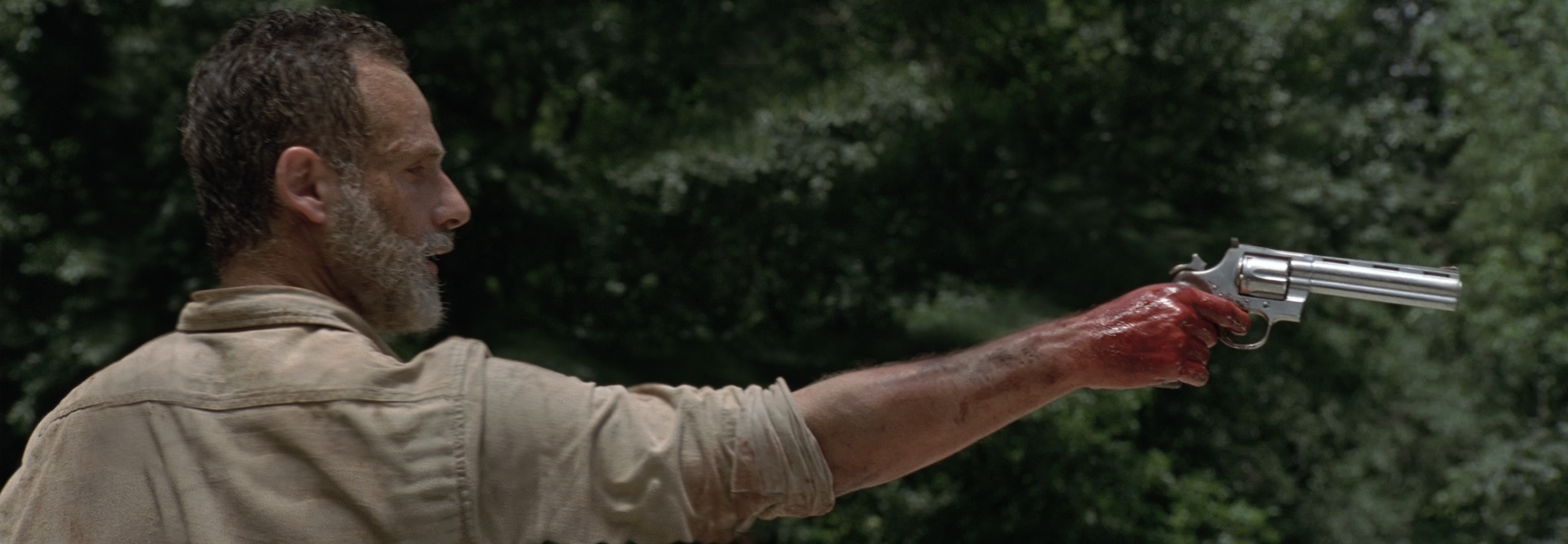 Rick Grimes aiming down the barrel of his extended colt python on the bridge